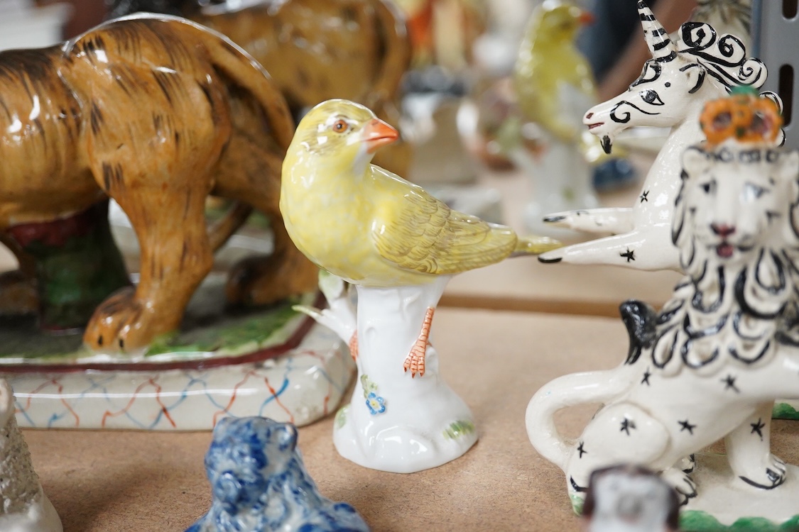 A collection of 19th/20th century Staffordshire and continental porcelain models of animals and birds, including a 20th century Meissen figure of a canary, two Continental porcelain Panthers, two similar recumbent dogs,